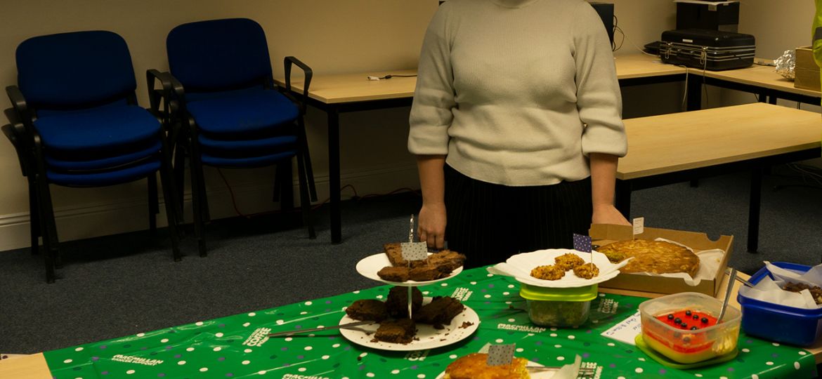 Girl standing around table for Macmillan Coffee morning