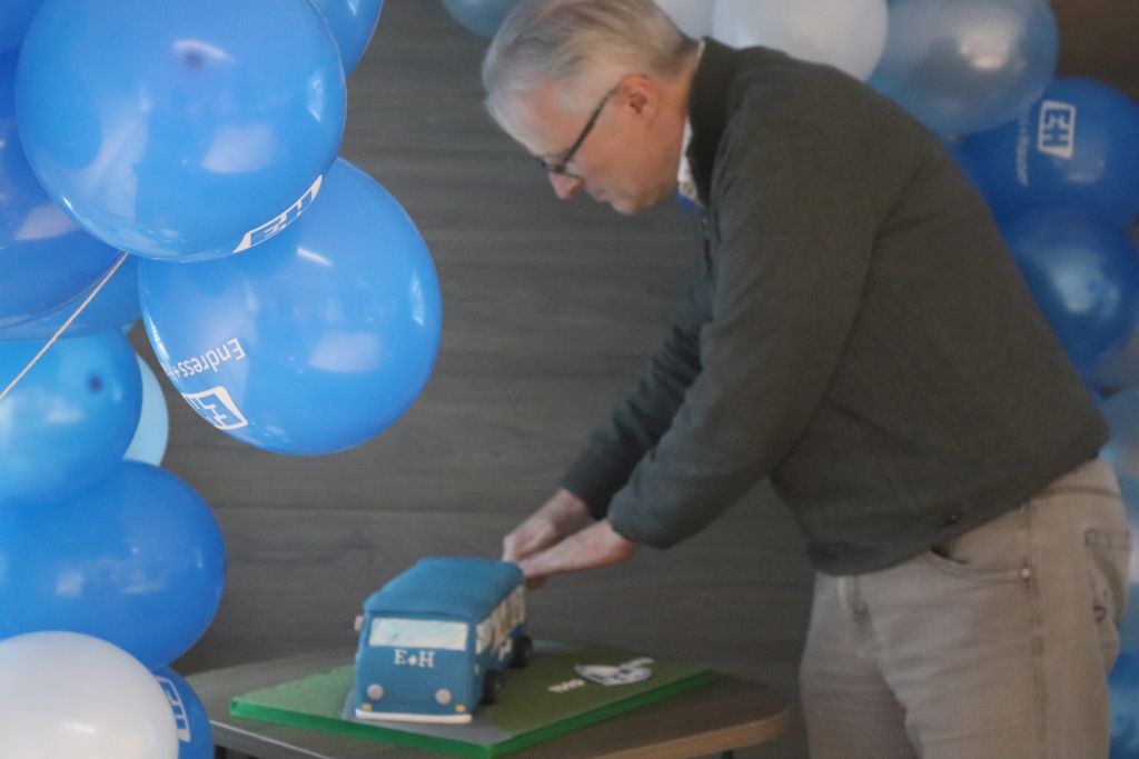 Cake being cut under arch