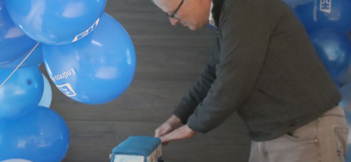 Cake being cut under arch